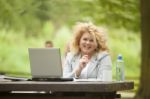 Business Lady Using Laptop In Park Stock Photo