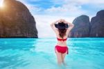 Young Woman In Red Bikini Sitting On The Beach Stock Photo