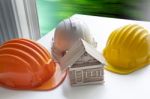 Model Of Wood House On Architect Working Table And Safety Helmet Stock Photo