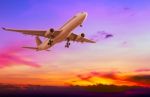 Commercial Airplane Flying At Sunset Stock Photo