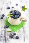 Jug Of Blueberries On White Wooden Table Stock Photo