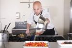 Chef In Kitchen Cooking, He Is Working On The Sauce For The Food Stock Photo