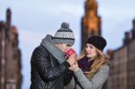 Young Couple In Love Embracing And Drinking Hot Drink From Red C Stock Photo