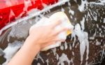 Hand Washing Brown Car With Blue Sponge And Bubbles Stock Photo