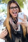 Portrait Of Beautiful Girl Drinking Coffee And Using Her Mobile Stock Photo