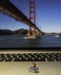 Man Riding Bicycle Model On Laptop With Golden Gate Bridge Background Stock Photo