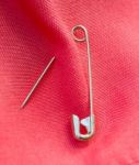 Safety Pin Means Sewing Needle And Dressmaking Stock Photo