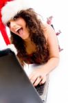 Woman Wearing Christmas Hat And Working On Laptop Stock Photo