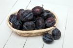 Tasty Purple Plums Isolated On A White Wooden Background Stock Photo