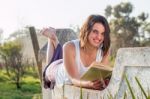 Girl Reading Book Outdoors Stock Photo