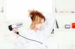 Girl Drying Her Hair At Home Stock Photo