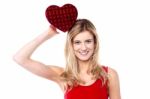 Cheerful Girl Holding Heart Shaped Gift Stock Photo