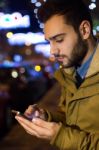 Portrait Of Young Man Using His Mobile Phone On The Street At Ni Stock Photo