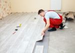 Handyman Laying Down Laminate Flooring Boards Stock Photo