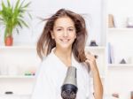 Woman Drying Hair At Home Stock Photo