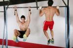 Athletic Group Executing Exercise Tightening On Horizontal Bar Stock Photo