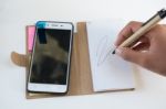 Mobile Phone Notebook And Pen On White Background Stock Photo