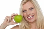 Closeup Shot Of A Cheerful Woman Holding An Apple Stock Photo