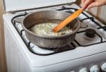 Woman Frying Onions Stock Photo