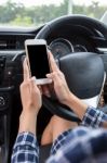 Young Female Driver Using Touch Screen Smartphone In A Car Stock Photo