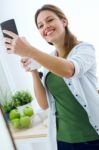 Beautiful Young Woman Using Her Mobile Phone And Enjoying Breakf Stock Photo