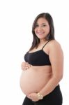 Young Pregnant Woman Smiling At Camera Against White Background Stock Photo