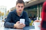 Young Entrepreneur Using His Mobile Phone At Coffee Shop Stock Photo