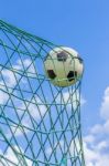 Football Caught In Goal Net With Blue Sky Stock Photo