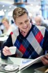 Guy Reading Newspapers And Drinking Coffee Stock Photo