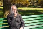 Elderly Gray-haired Man In Glasses Smoking A Cigarette In City P Stock Photo