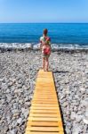 Woman Standing On Wooden Path At  Sea Stock Photo