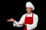 Smiling Male Chef Presenting Something Stock Photo