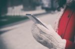 Woman In Red Coat With Smartphone In Hands Going Through The Cit Stock Photo