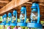 Perspective View Of Storm Lanterns Hanged On Wooden Counterpoise Stock Photo