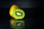 Kiwi Fruit On Black Stone With Water Reflection Low Key Light Stock Photo