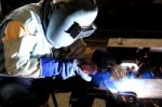 Industrial Worker Welding In Factory Stock Photo