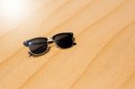 Black Sunglasses On Summer Desert Sand Dunes  On The Sand Stock Photo