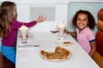 Little Girls Enjoying Pizza In A Restaurant Stock Photo