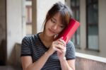 Portrait Of Thai Adult Beautiful Girl Reading Red Book Stock Photo