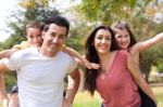 Parents Piggy Back Their Children Stock Photo