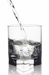 Water With Air Bubbles Pouring Into Glass With Its Reflection, C Stock Photo