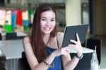 Portrait Of Thai Adult Beautiful Girl Using Her Tablet And Smile In University Stock Photo