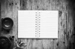 Open Notebook And Pen On Old Wooden Background, Black And White Stock Photo