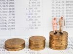 Miniature Senior Couple Stand On Pile Of Euro Coins. Retirement Stock Photo