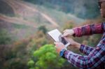 Tourists Look At A Map On The Tablet On Mountain Stock Photo