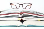 Glasses On Stack Of Open Books Stock Photo