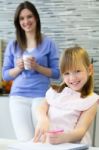 Child Drawing With Crayons With Her Mom At Home Stock Photo