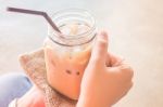 Hand On Glass Of Iced Milk Coffee With Vintage Filter Effect Stock Photo