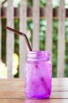 Iced Drink In Violet Glass In Coffee Shop Stock Photo