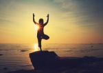 Silhouette Yoga Girl By The Beach At Sunrise Stock Photo